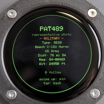 Close-up of the Blipscope round display showing an aircraft photo card with the MILITARY flag for callsign PAT489